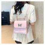 Cartera mochila pequeña con dije mariposa