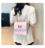 Cartera mochila pequeña con dije mariposa